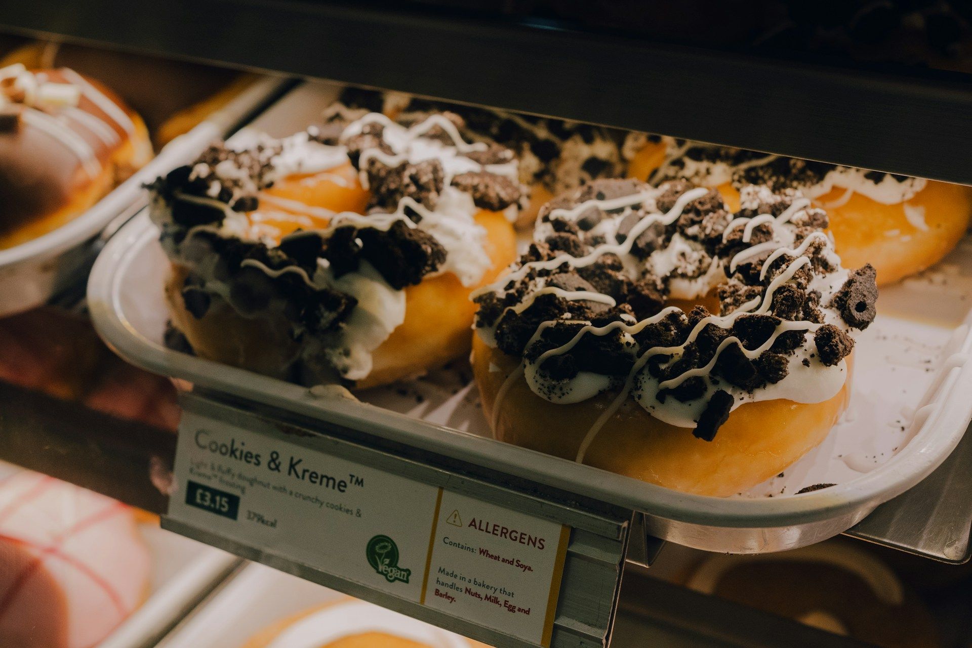 Assorted cream-filled pastries drizzled with chocolate on a display tray