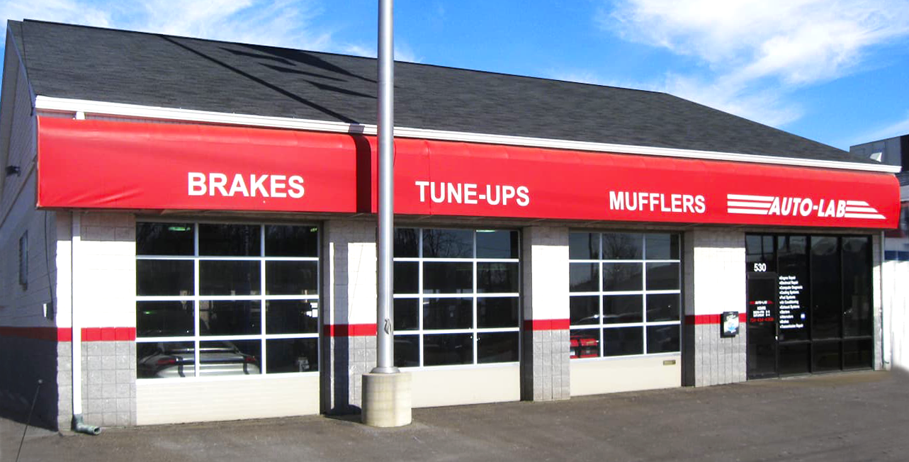 A garage with a red awning that says brakes tune-ups mufflers