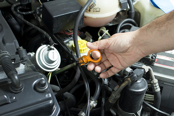 A person is checking the oil level in a car engine.