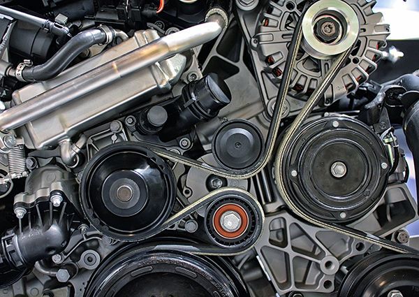 A close up of a car engine with a belt.