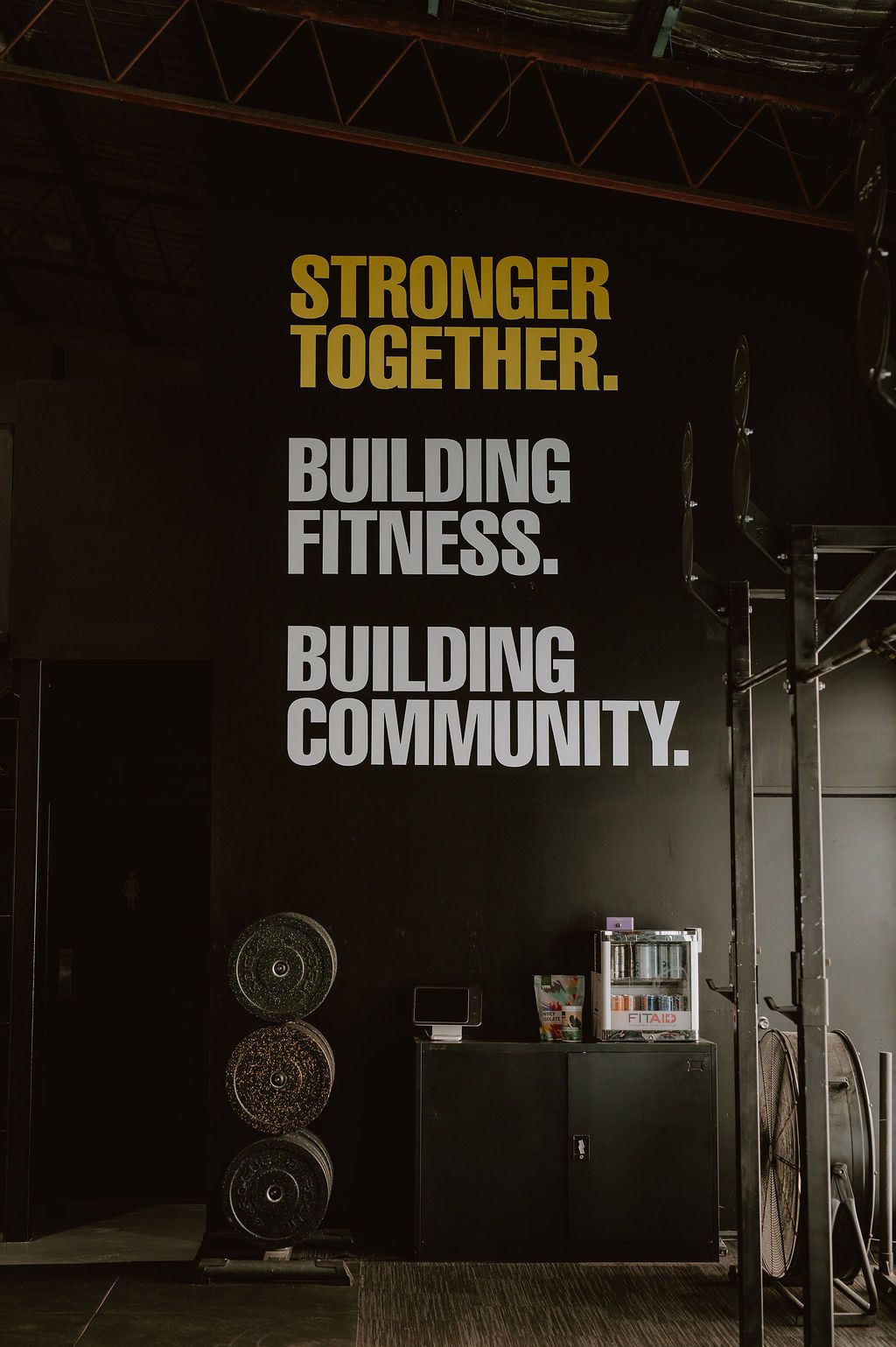 A gym wall features the text: