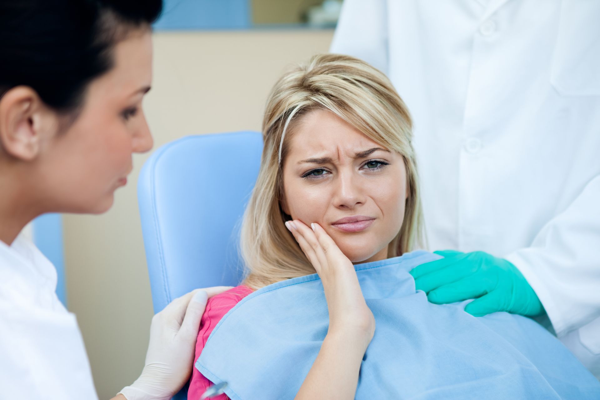 A woman is sitting in a dental chair with a toothache — Hobart, TAS — Moonah Dental Centre A woman is sitting in a dental chair with a toothache — Hobart, TAS — Moonah Dental Centre