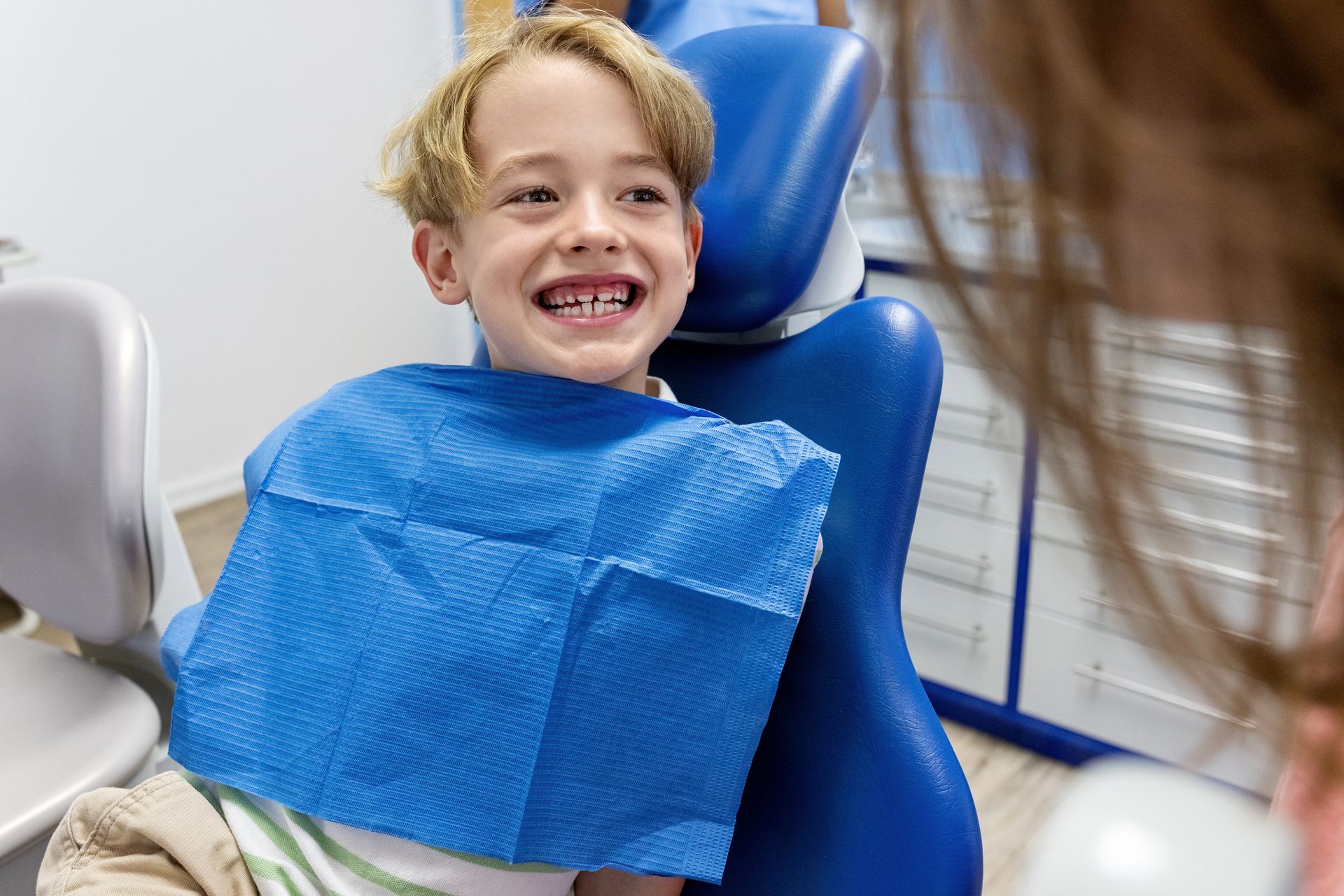 Child sitting confidently in a dentist chair.