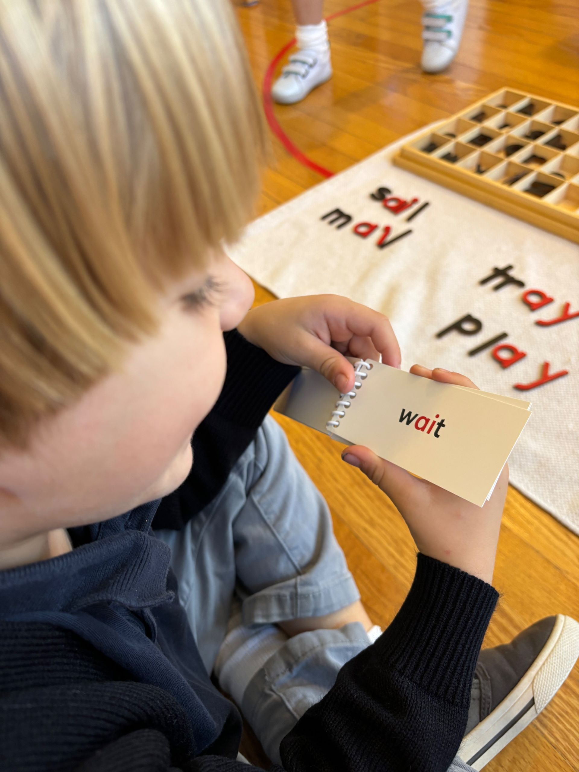 Montessori child reading working with montessori languaje materials
