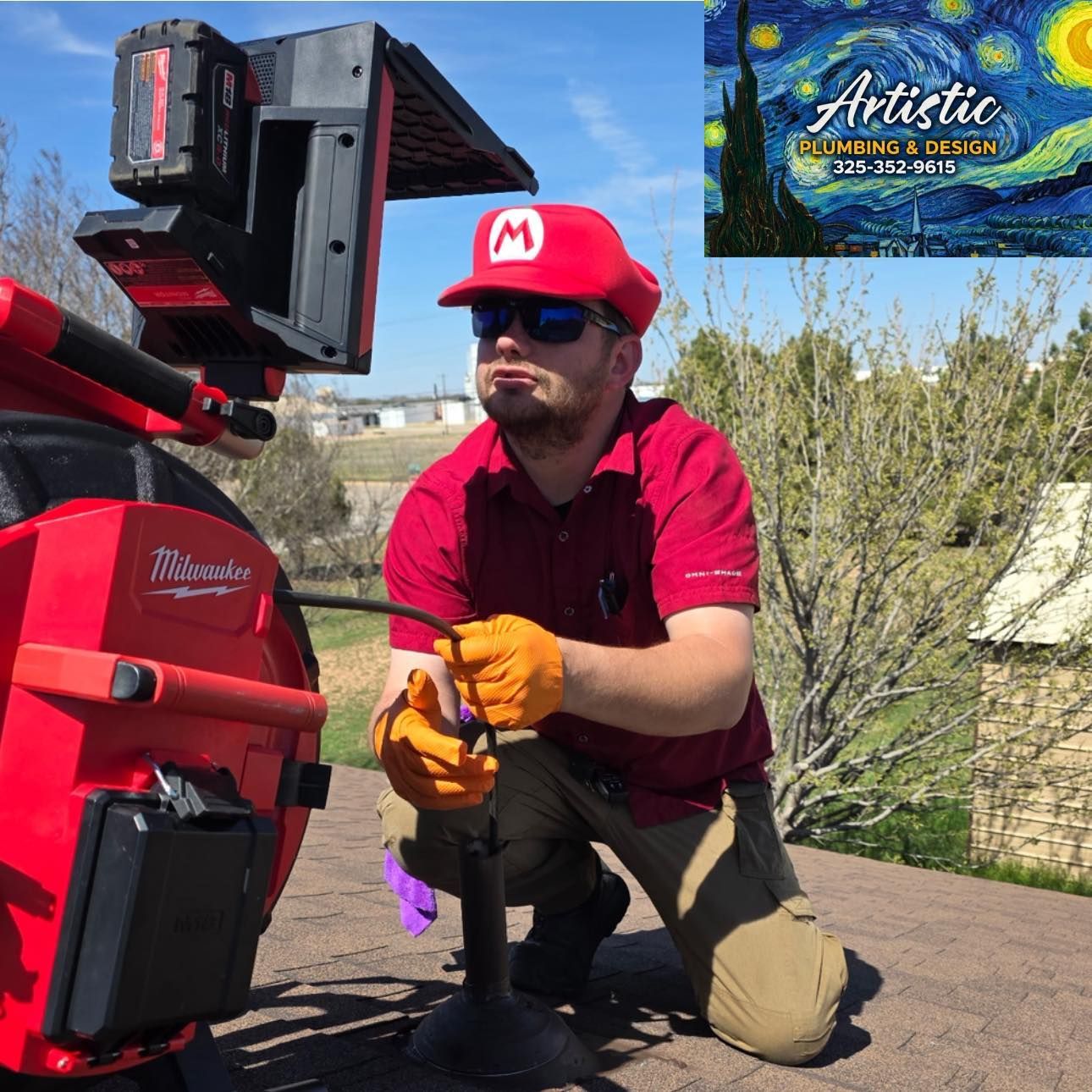 Worker kneeling beside red utility equipment outdoors, adjusting a part on a sunny day