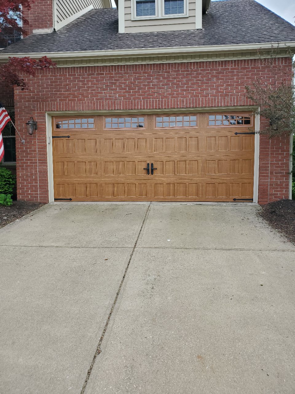 Brick house garage with a wooden double door and concrete driveway