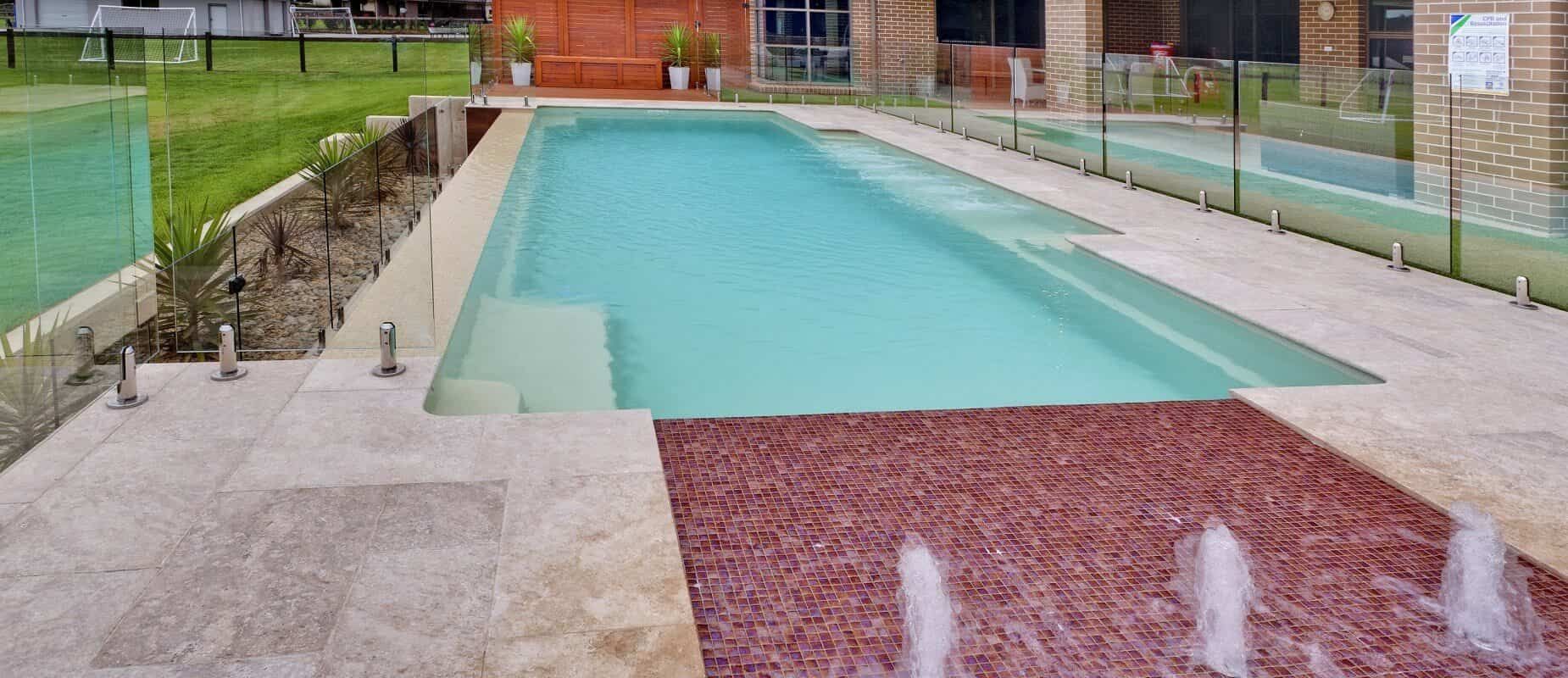 A Large Swimming Pool With a Fountain in the Middle of It — Azure Pools Mid North Coast In Taree, NSW