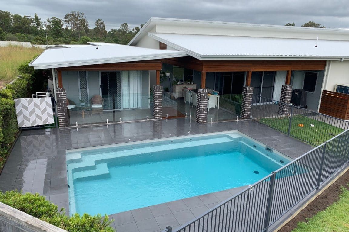 There is a Large Swimming Pool in the Backyard of a House — Azure Pools Mid North Coast In Gloucester, NSW