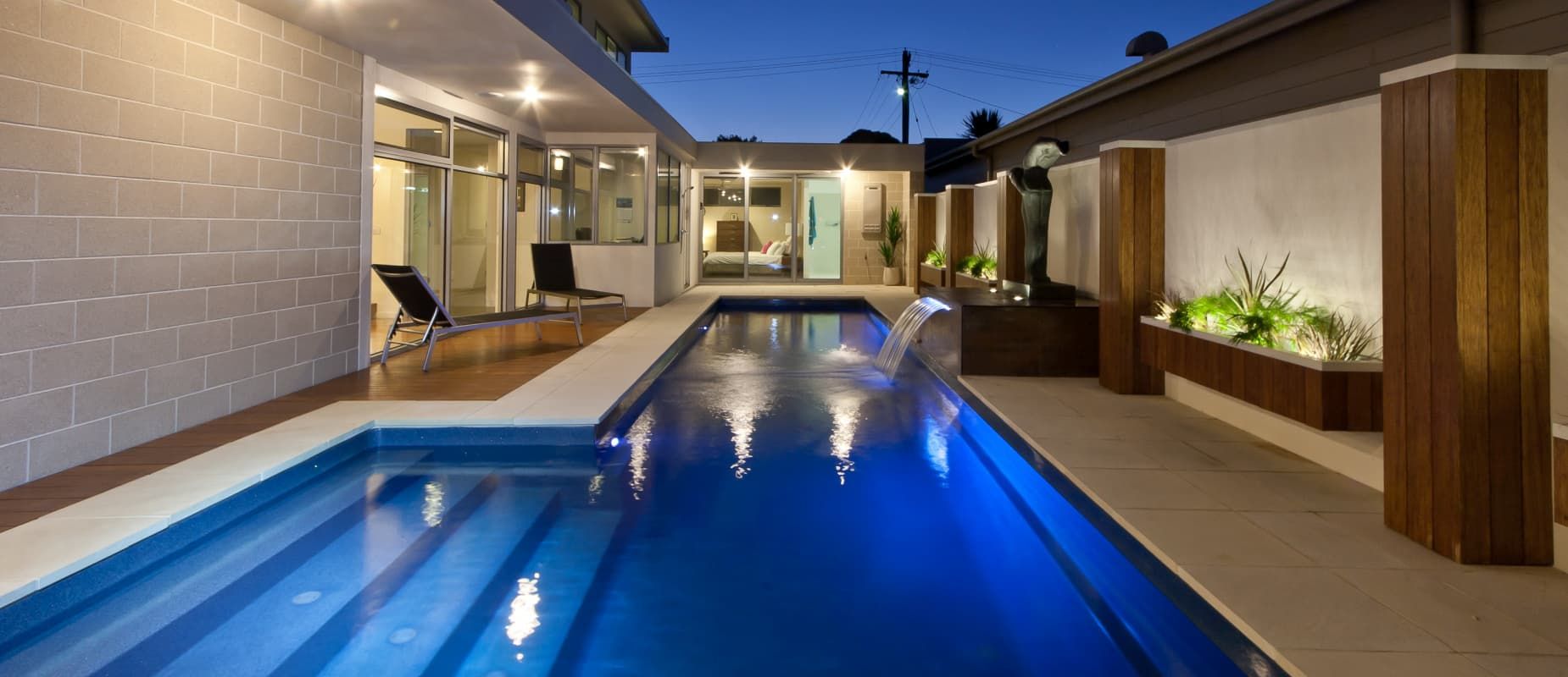 There is a Large Swimming Pool in the Backyard of a House — Azure Pools Mid North Coast In Nabiac, NSW