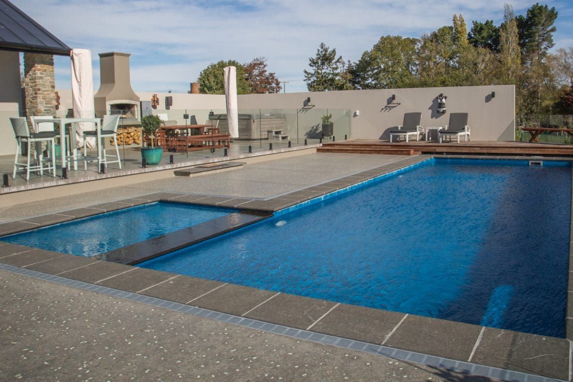 A Large Swimming Pool Surrounded by Chairs and Tables — Azure Pools Mid North Coast In Gloucester, NSW