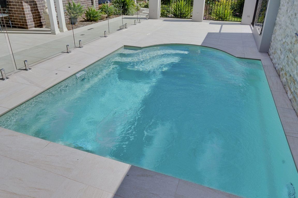 There is a Large Swimming Pool in the Backyard of a House — Azure Pools Mid North Coast In Diamond Beach, NSW