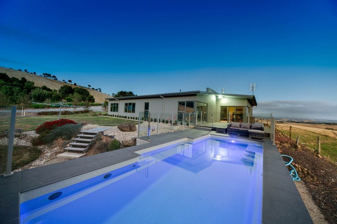 There is a Large Swimming Pool in Front of a House — Azure Pools Mid North Coast In Diamond Beach, NSW