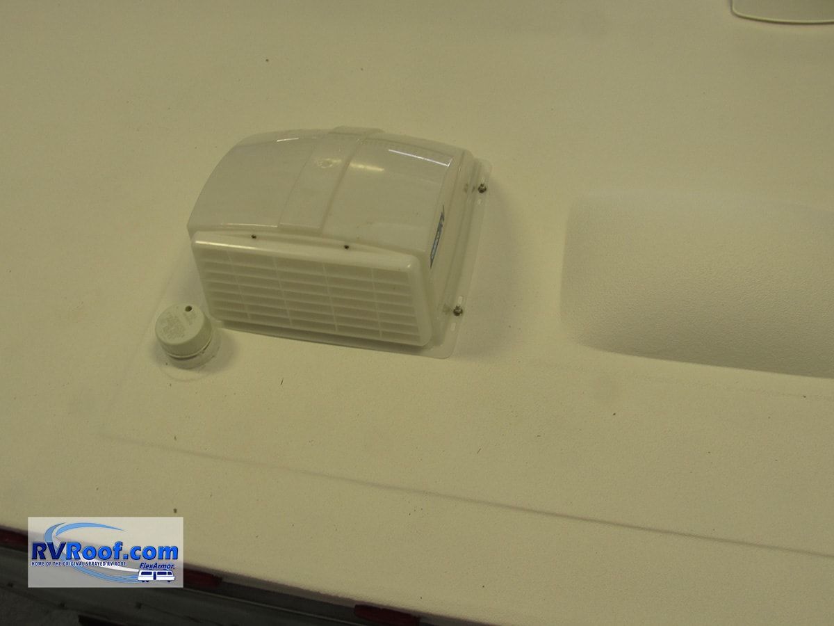 A white box is sitting on a white surface next to a rvroof.com logo