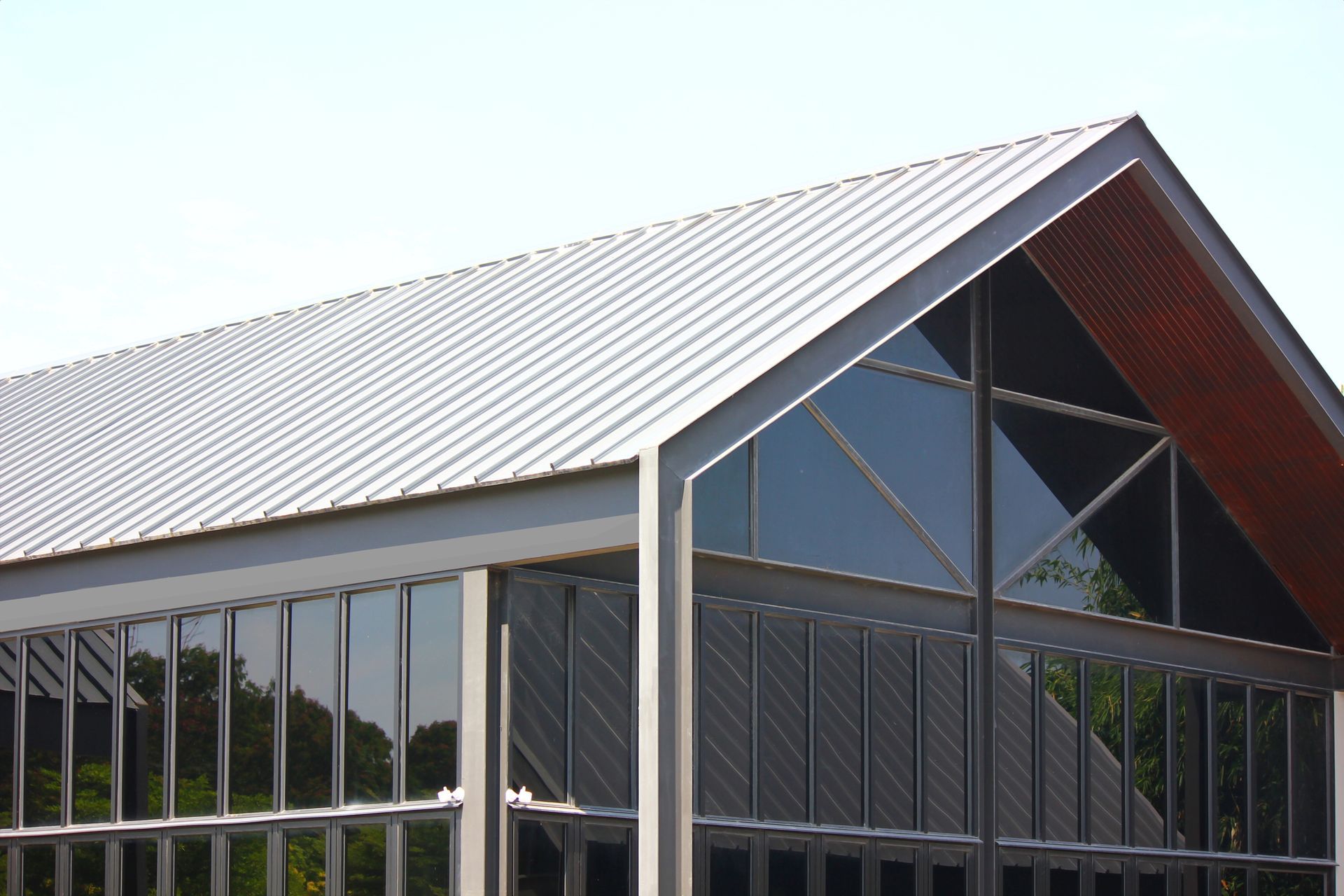 Modern building with angled metal roof and large glass windows.