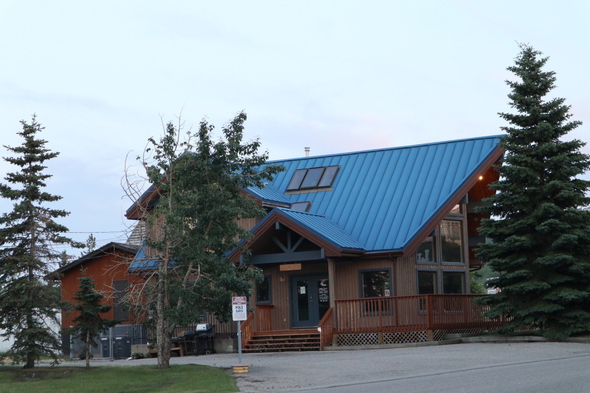 a house with a blue roof has a no parking sign in front of it