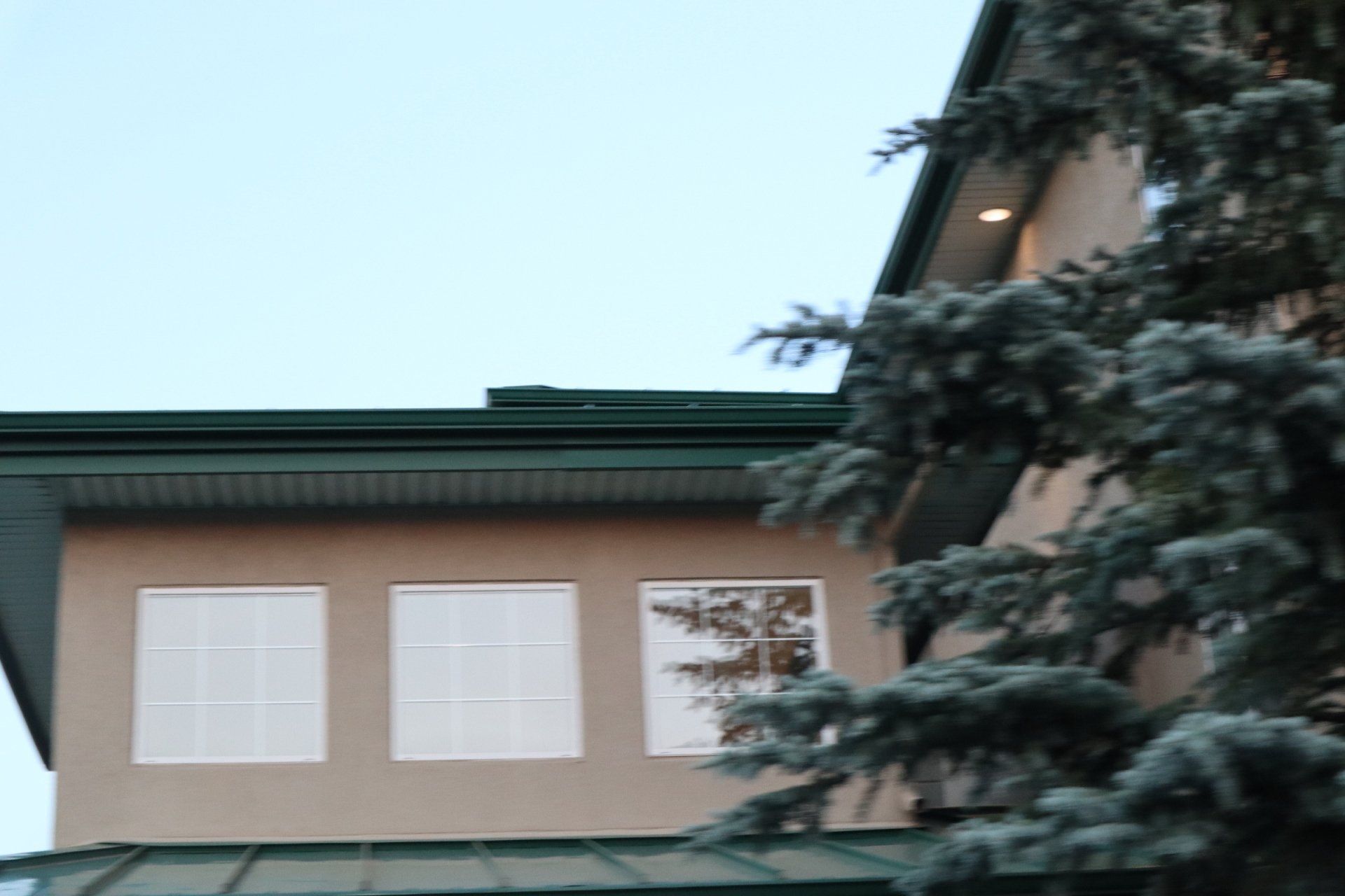 a house with a green roof and white windows