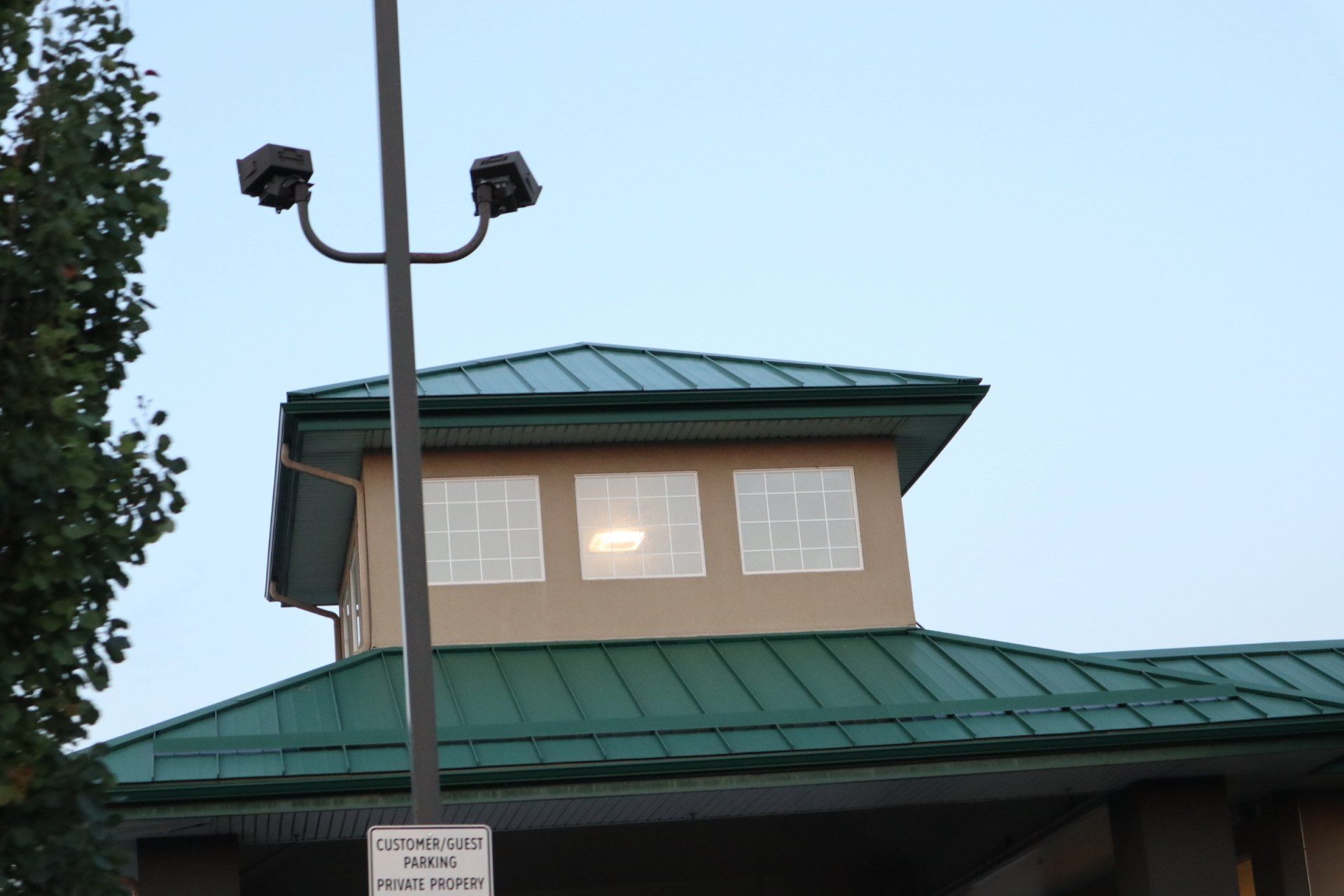 a building with a green roof and a sign that says customer owned parking