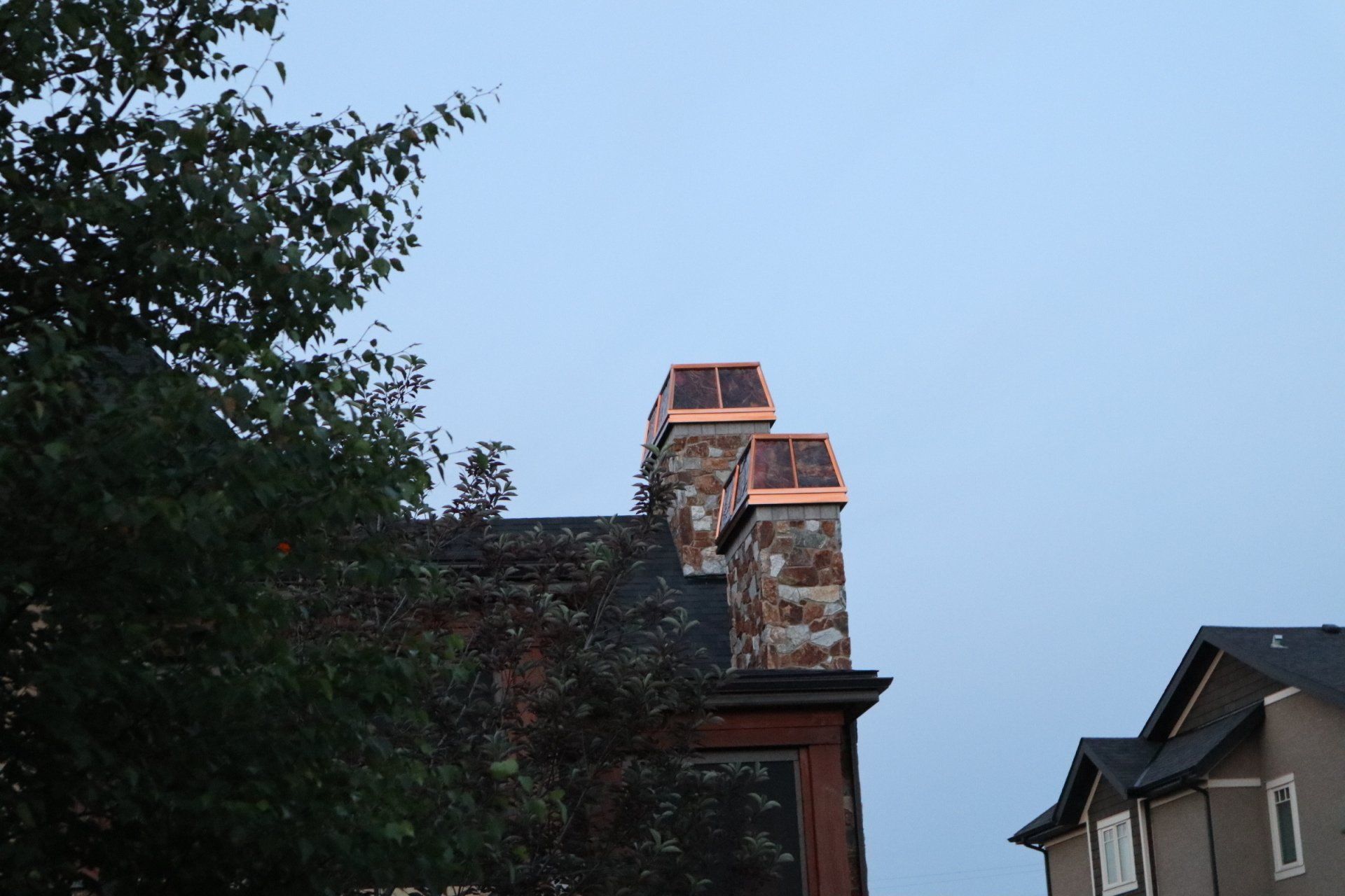 a copper chimney on the side of a house