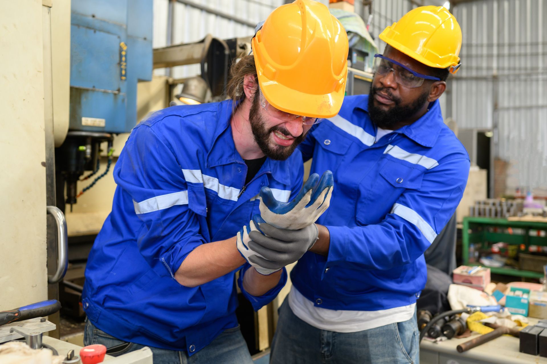Man injured at work, aided by a colleague.