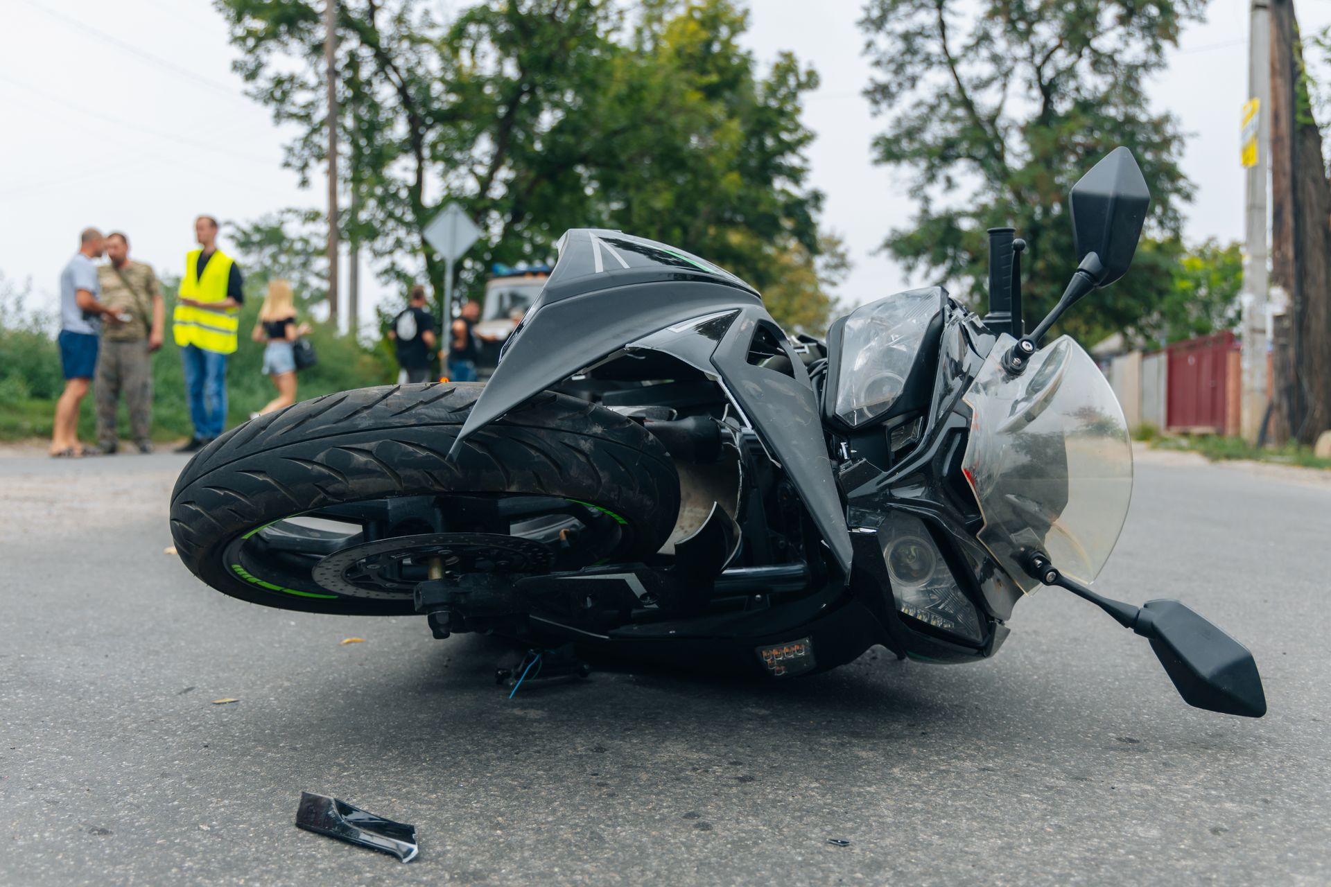Motorcycle on its side in road, damaged.