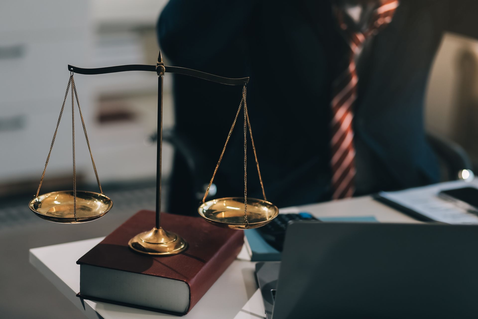 Gold justice scales on a law book.