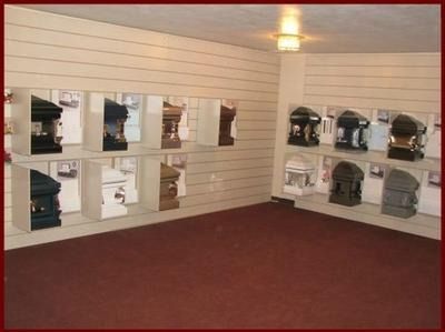 Interior of a store with rows of boxed headsets or helmets displayed on white wall shelves, red carpet floor