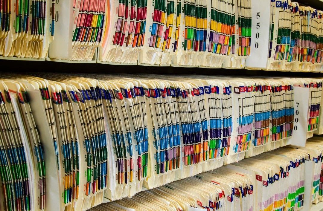 A room filled with shelves of medical records before document destruction by Documentshredding.