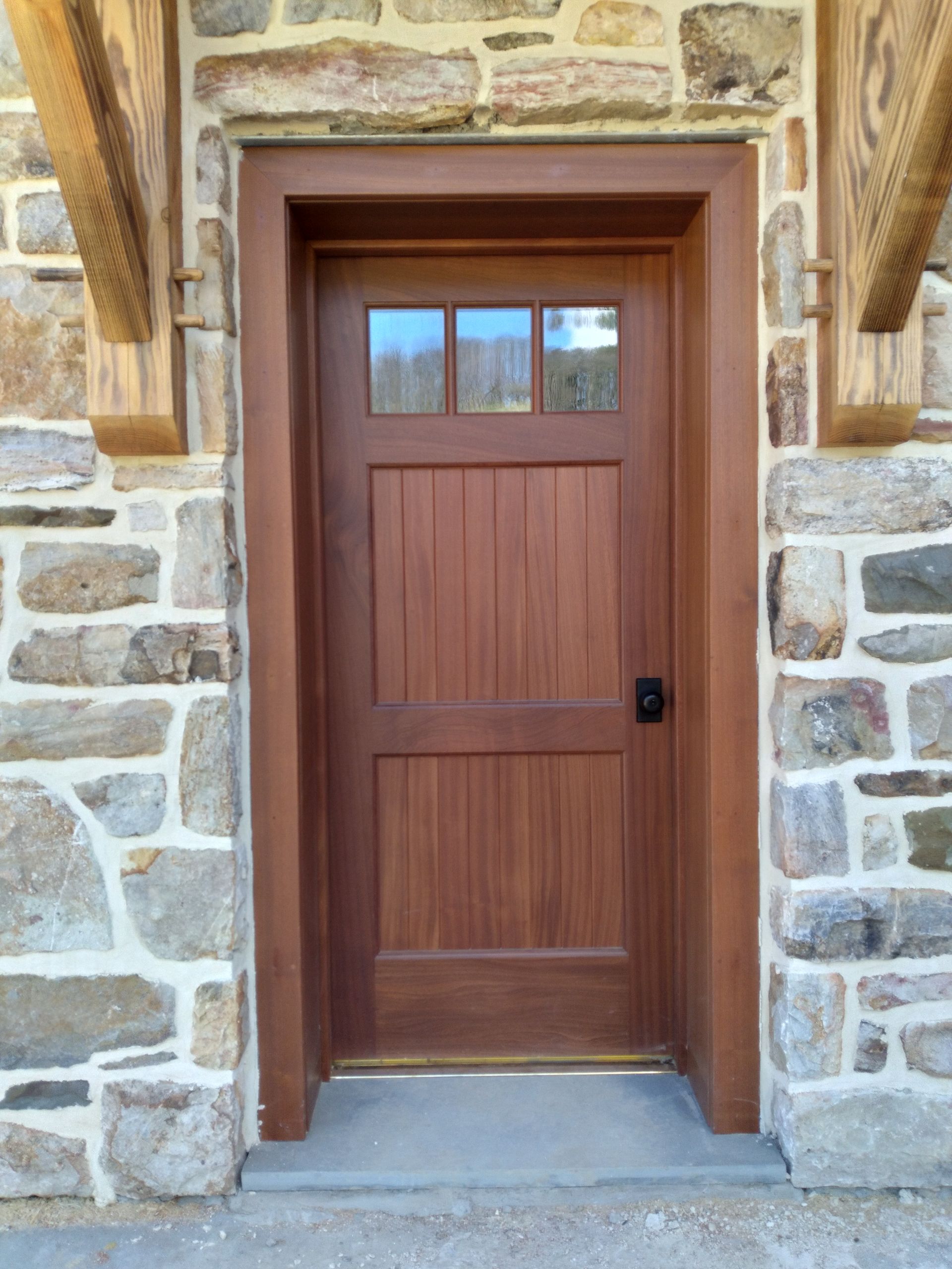 A Wooden Door Is in Front of A Stone Wall | Narvon, PA | JDH Custom Millwork