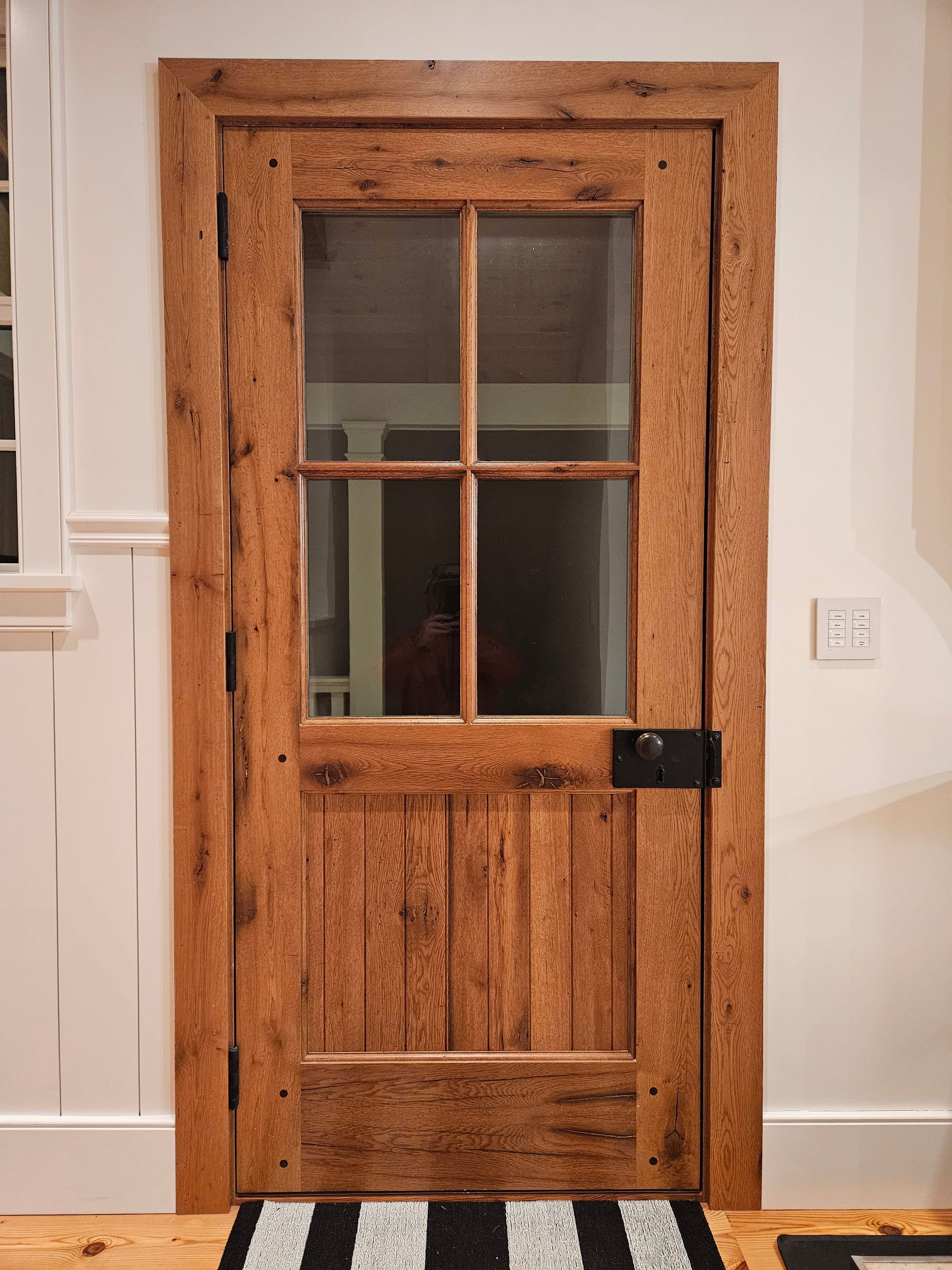 A Wooden Door with A Glass Window and A Black and White Striped Rug on The Floor | Narvon, PA | JDH Custom Millwork