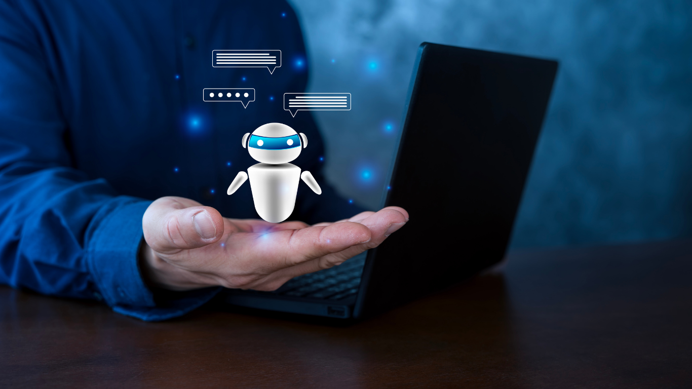 Hand holding a small robot icon beside a laptop, with blue digital interface graphics in the background