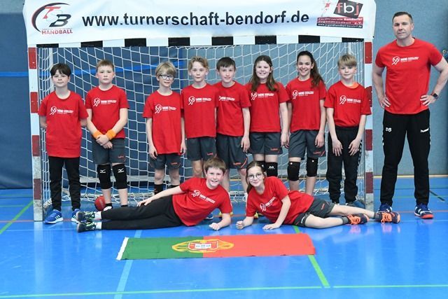 Eine Gruppe Kinder posiert vor einem Tor für ein Foto.