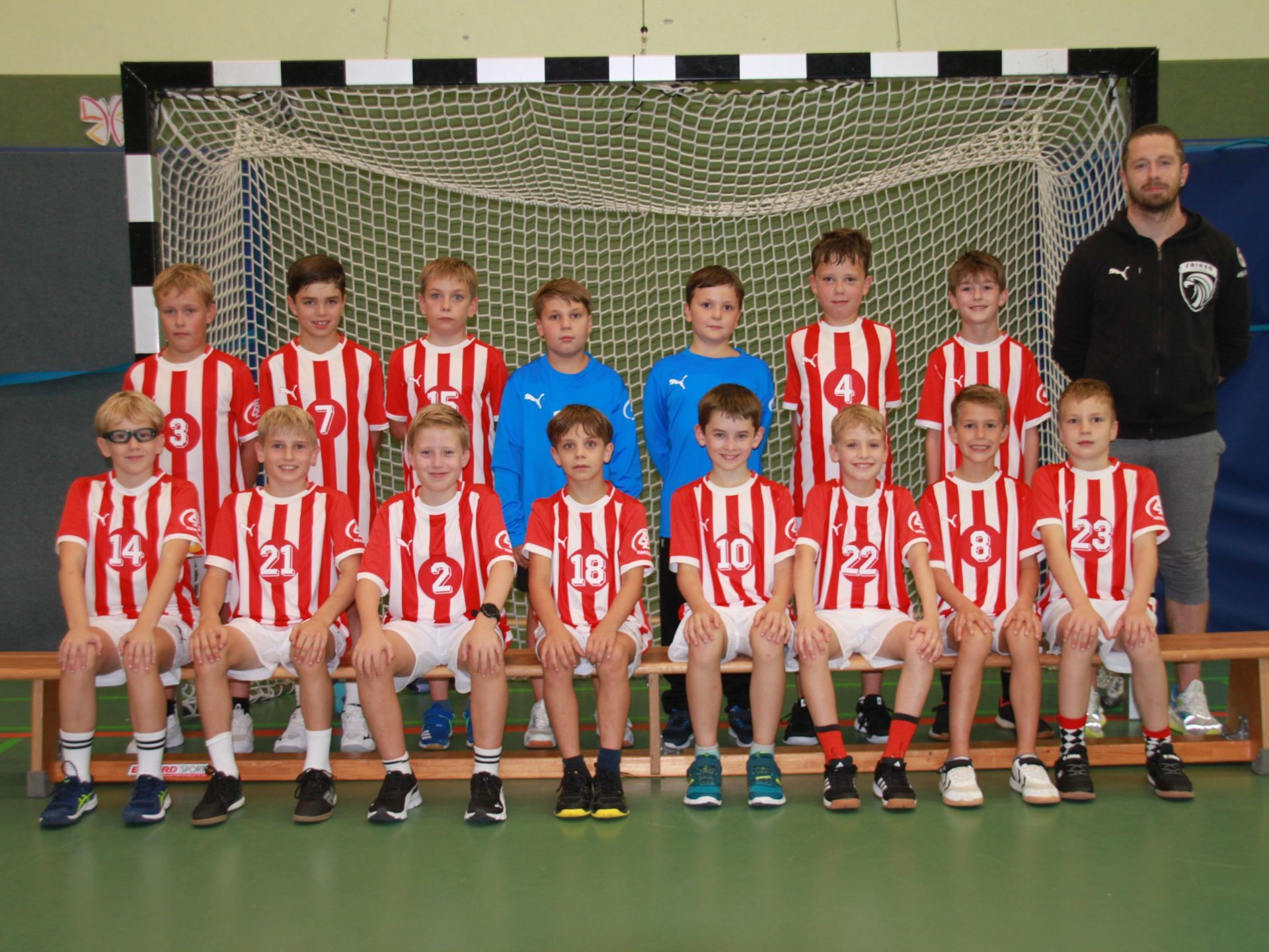 Eine Gruppe Kinder posiert vor einem Tor für ein Foto.