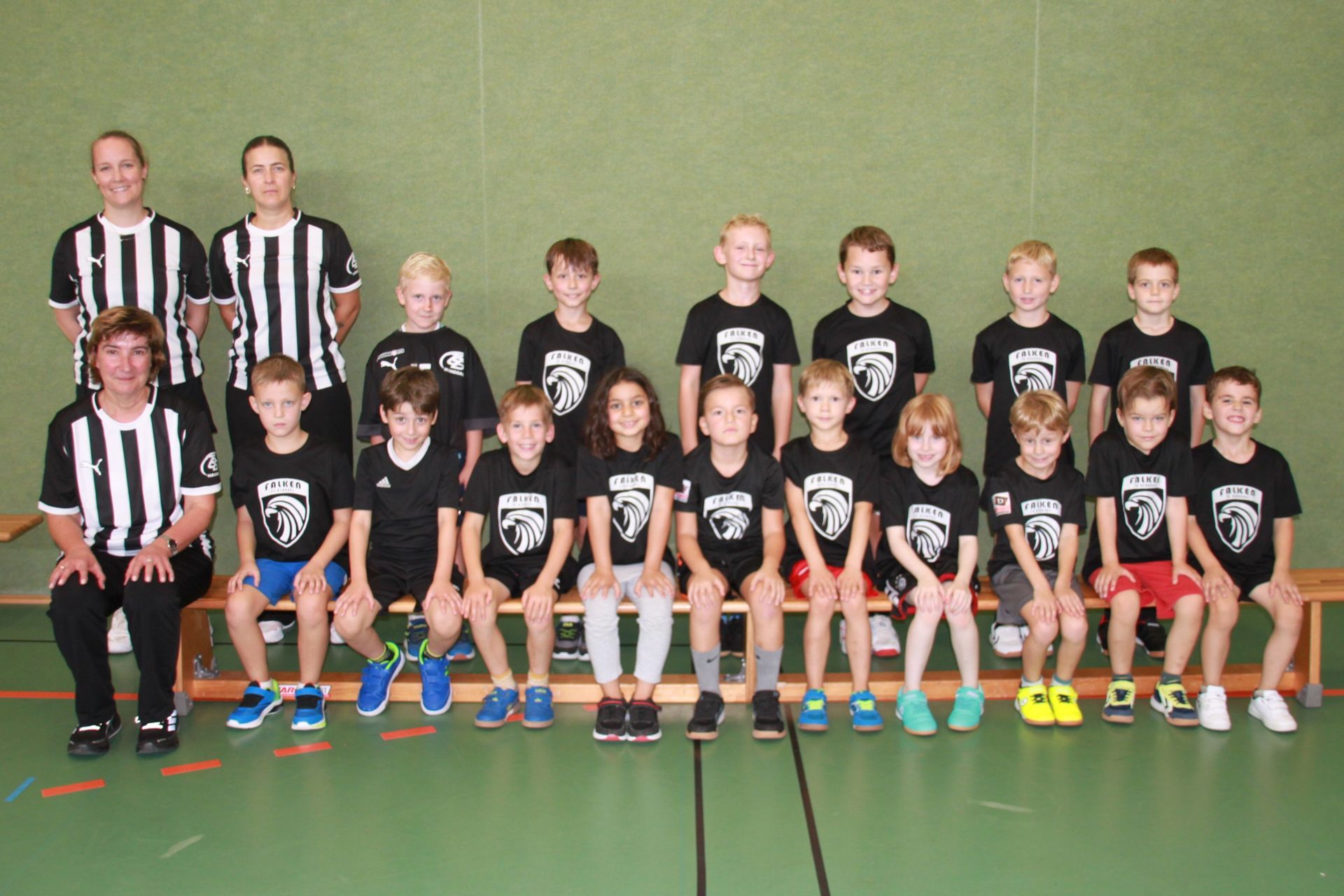 Eine Gruppe Kinder posiert mit Fußbällen für ein Foto.