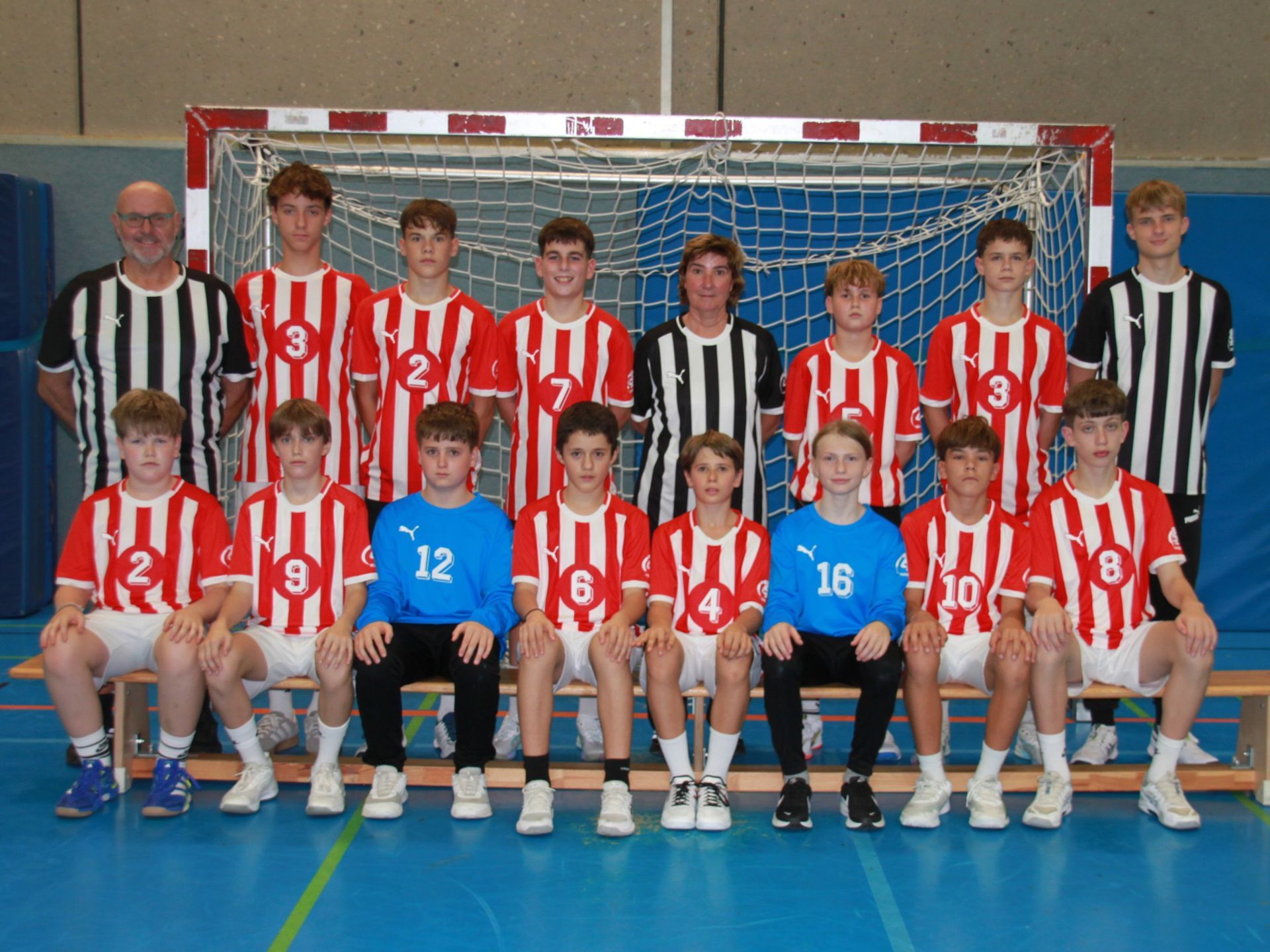 Eine Gruppe junger Jungen posiert vor einem Fußballtor für ein Foto.