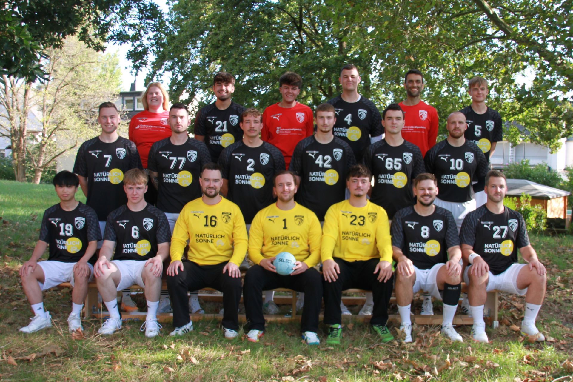 Eine Gruppe von Leuten spielt in einer Turnhalle Fußball.