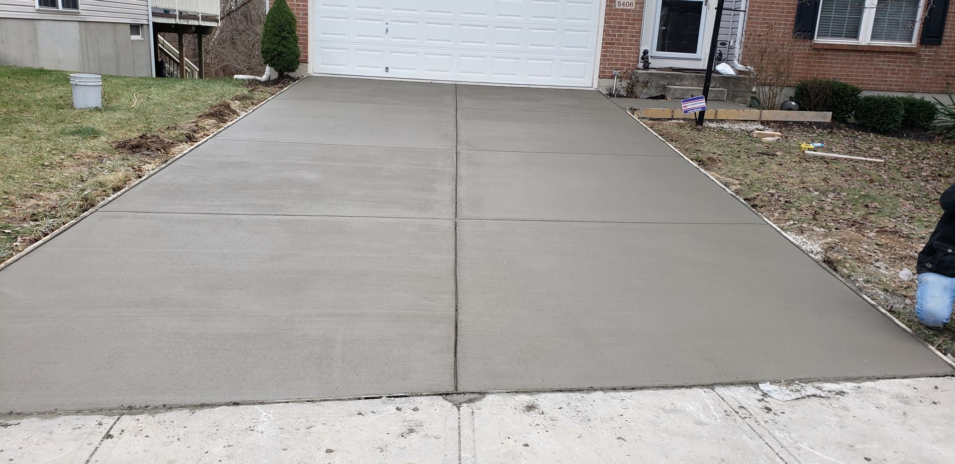 A concrete driveway is being built in front of a house.