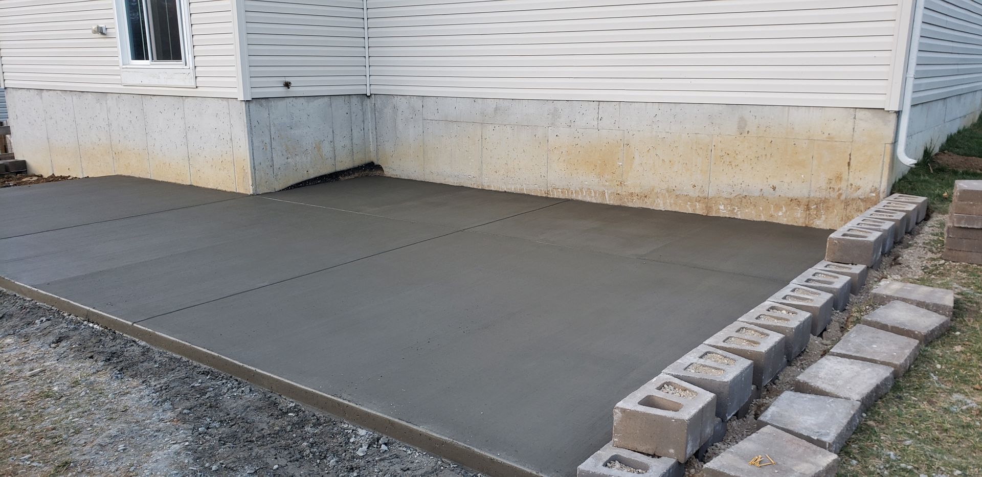 A concrete driveway is being built in front of a house.