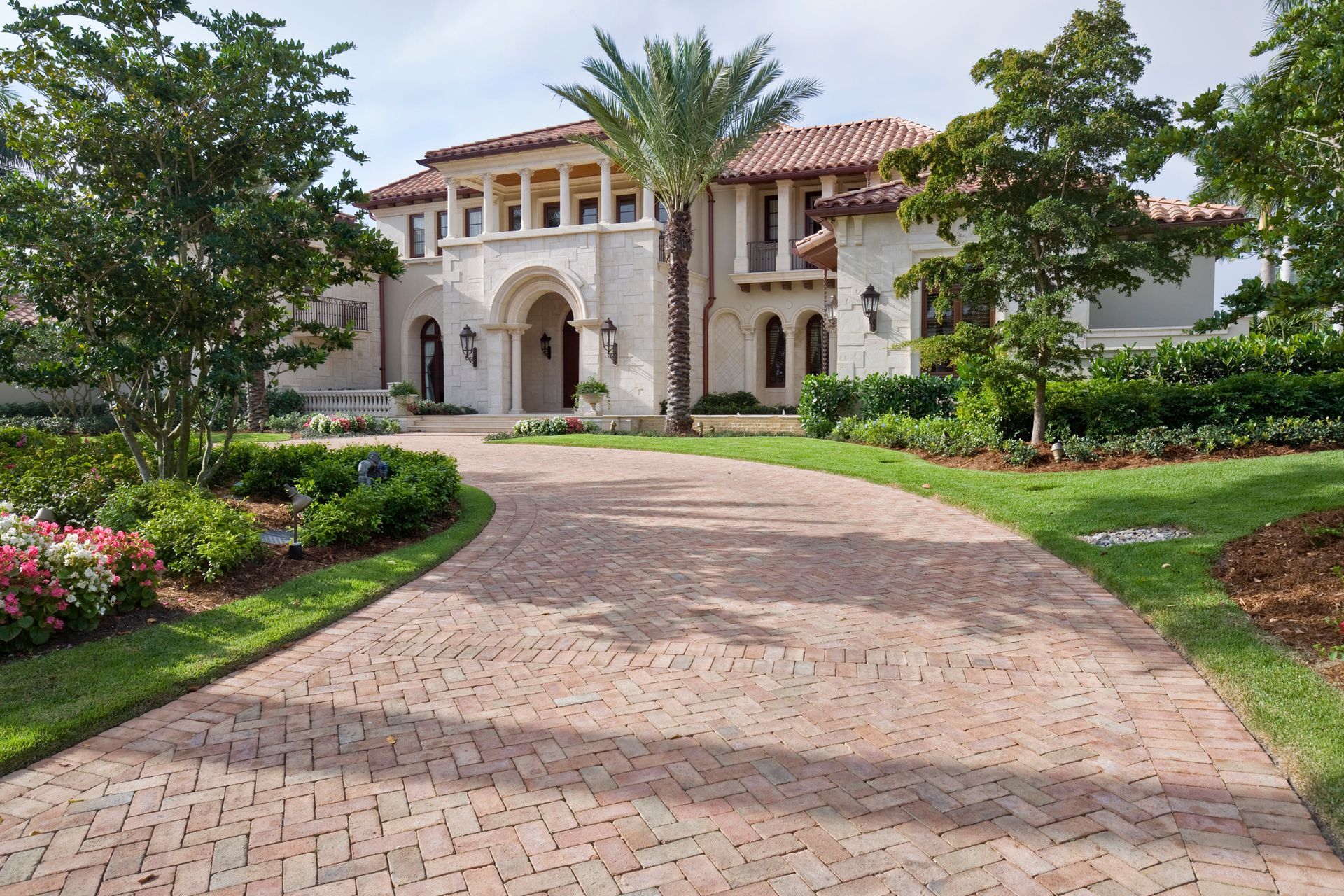 A large house with a brick driveway leading to it