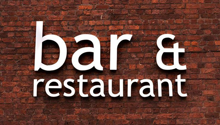 White “bar & restaurant” text on a red brick wall sign.