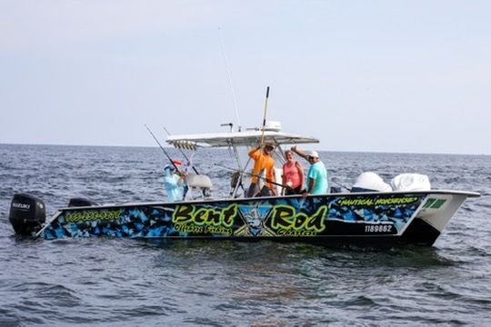 Four people fishing from a blue-patterned boat labeled 