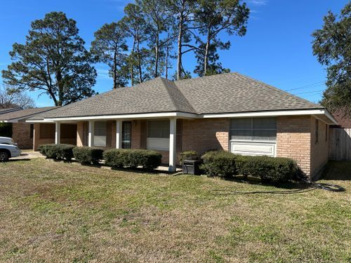 A brick house with a car parked in front of it.