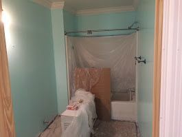A bathroom with a tub and shower being painted.
