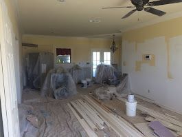 A living room with a ceiling fan and a lot of wood.