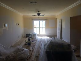 A living room with a ceiling fan and a large window.