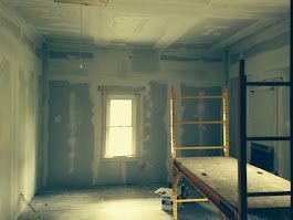 A room with a scaffolding and a bed in it.