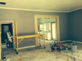 A room that is being painted with a scaffolding in the middle of it.