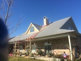 A house with a metal roof is being remodeled.