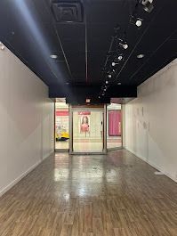 A large empty room with a wooden floor and a black ceiling.