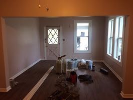 An empty living room with a wooden floor and a door.