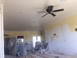 A ceiling fan is hanging from the ceiling of a living room.